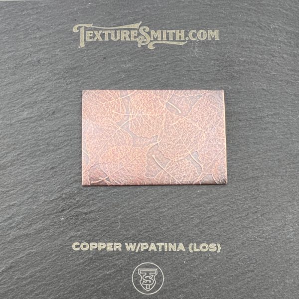 Copper sample with patina on black background.
