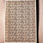 Wooden card with intricate spiral design.