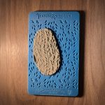 Textured clay on blue leaf pattern stencil.