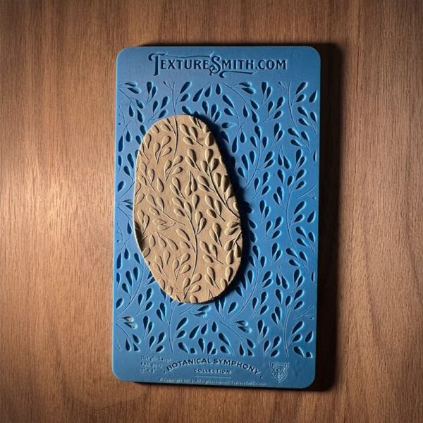 Textured clay on blue leaf pattern stencil.