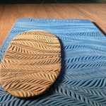 Clay on patterned blue silicone mold.