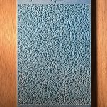 Blue textured sample on wooden surface.