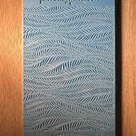 Embossed blue texture sample on wood surface.