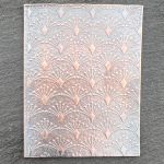 Embossed metallic pattern on textured surface.