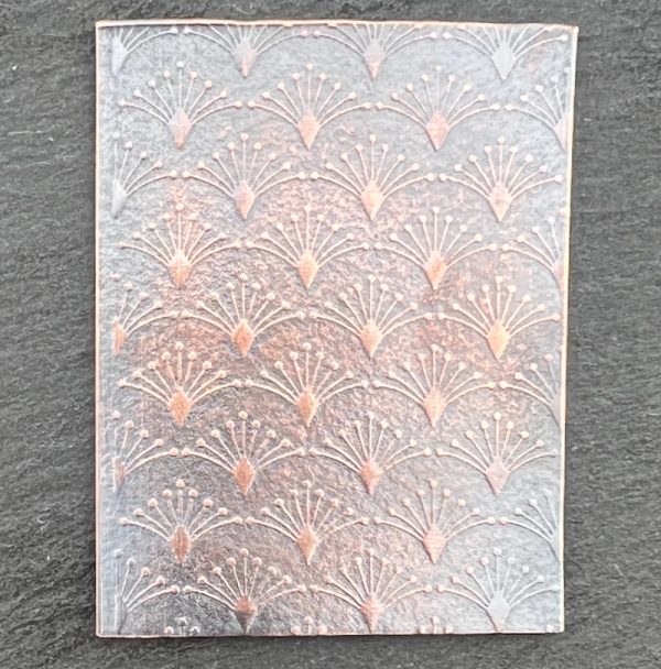 Embossed metallic pattern on textured surface.