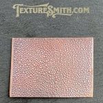 Textured copper sheet on dark background.