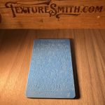 Blue card with abstract patterns on wood.