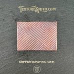 Copper patina textured sample on display board.