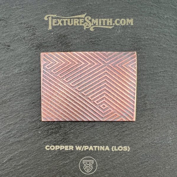 Copper patina textured sample on display board.