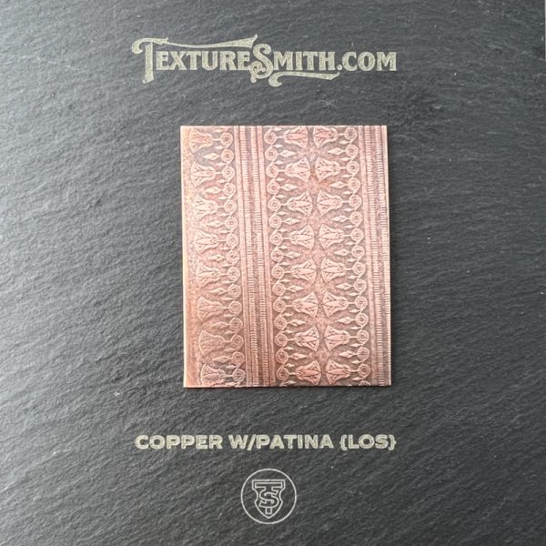 Copper plate with intricate patina design.
