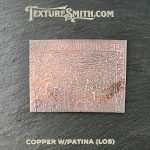 Copper plate with intricate patina design.