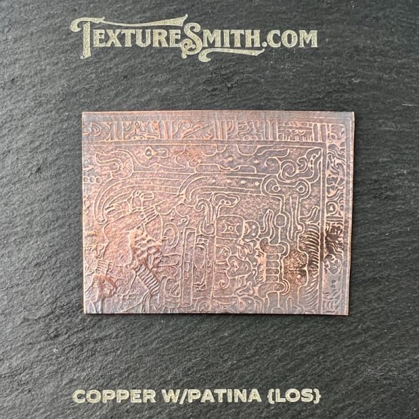 Copper plate with intricate patina design.