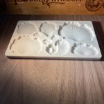 Silicone mold with shell designs on wood.
