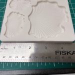 Leaf-shaped mold with ruler for scale.