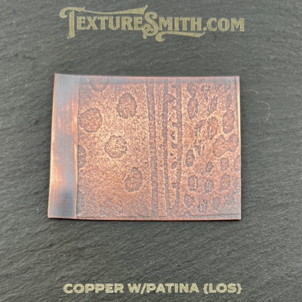 Textured copper sheet with patina design.