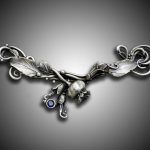 Intricate silver brooch with leaf design.
