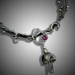 Silver necklace with purple gemstone and pendant.