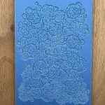 Blue textured stencil on wooden surface.
