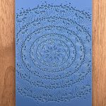 Blue stencil with intricate floral pattern design.