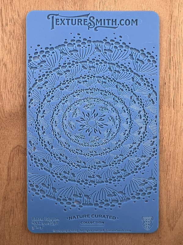 Blue stencil with intricate floral pattern design.