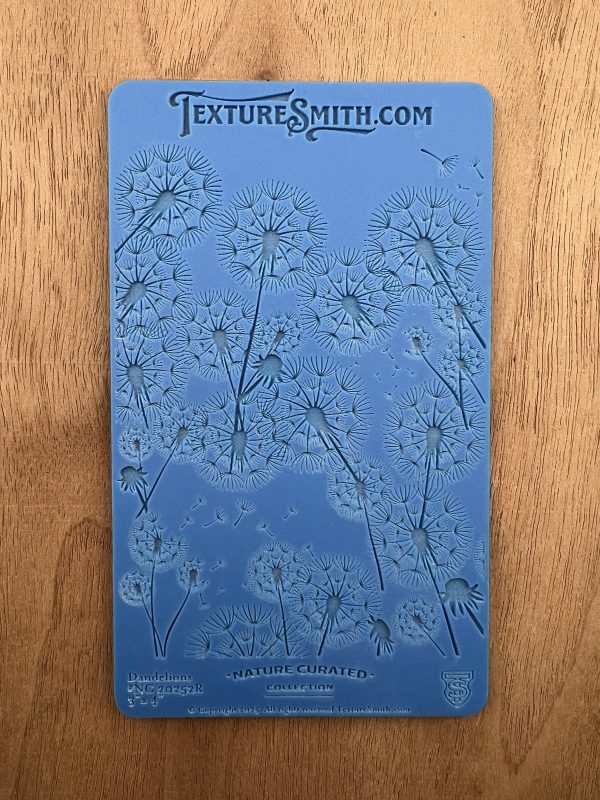 Blue dandelion-patterned texture sheet on wood.