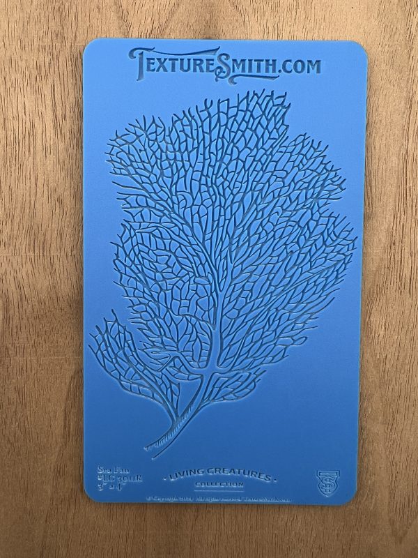 Blue stencil with intricate branching pattern.