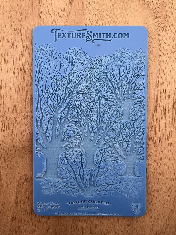Blue embossing mat with tree design.