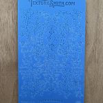 Blue embossed texture sheet with floral design.