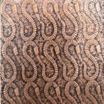 Wooden surface with carved abstract pattern.