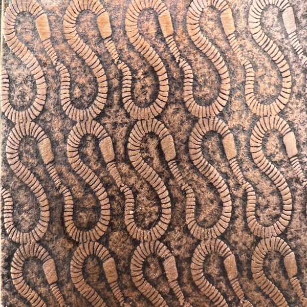 Wooden surface with carved abstract pattern.