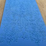 Blue embossed texture sheet with leaf pattern.