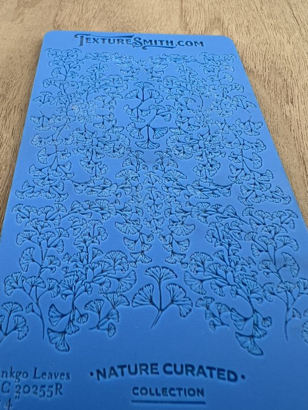 Blue embossed texture sheet with leaf pattern.