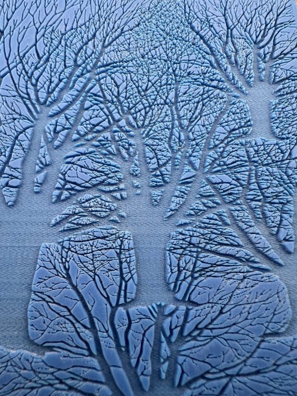 Blue abstract trees with intricate branch patterns.