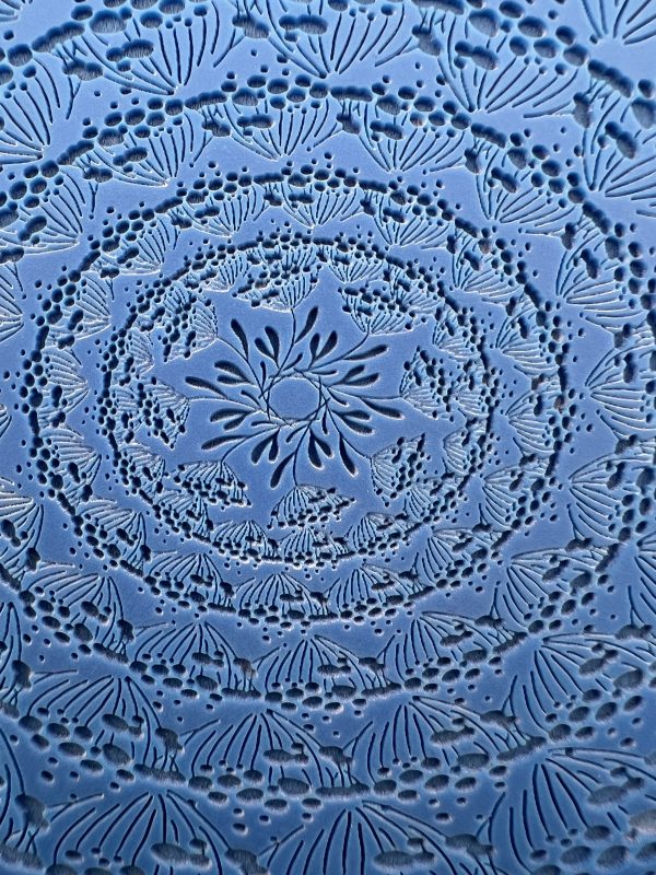 Intricate floral mandala pattern on blue background.
