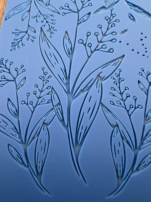 Embossed blue design with leafy patterns.