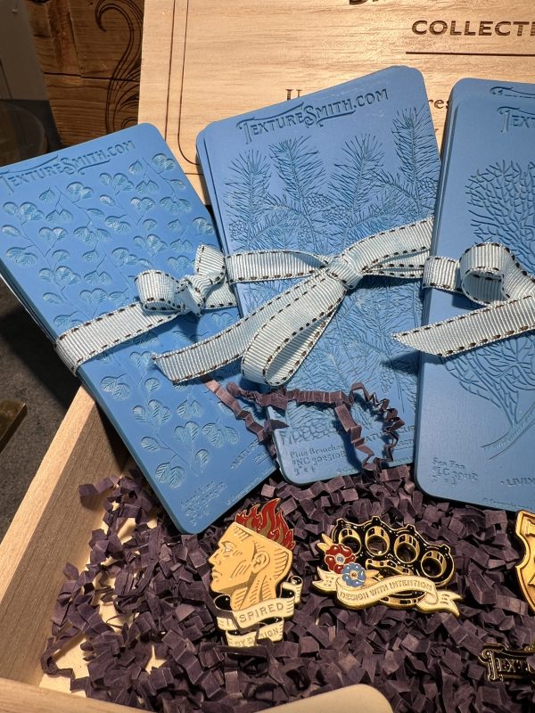 Blue textured cards with decorative pins displayed.