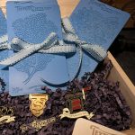 Blue booklets and pins in a wooden box.