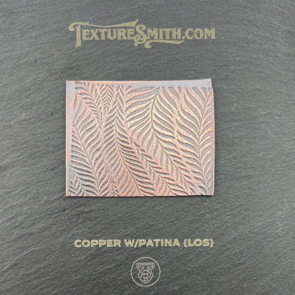 Decorative wallpaper sample with a gold leaf pattern on a beige background.