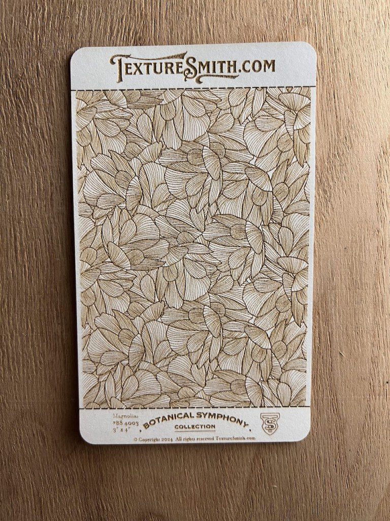 Sample of textured wallpaper with floral pattern in beige tones.