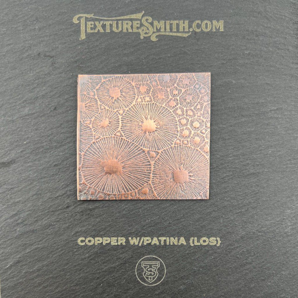A textured sample card with circular, lace-like patterns on a beige background.