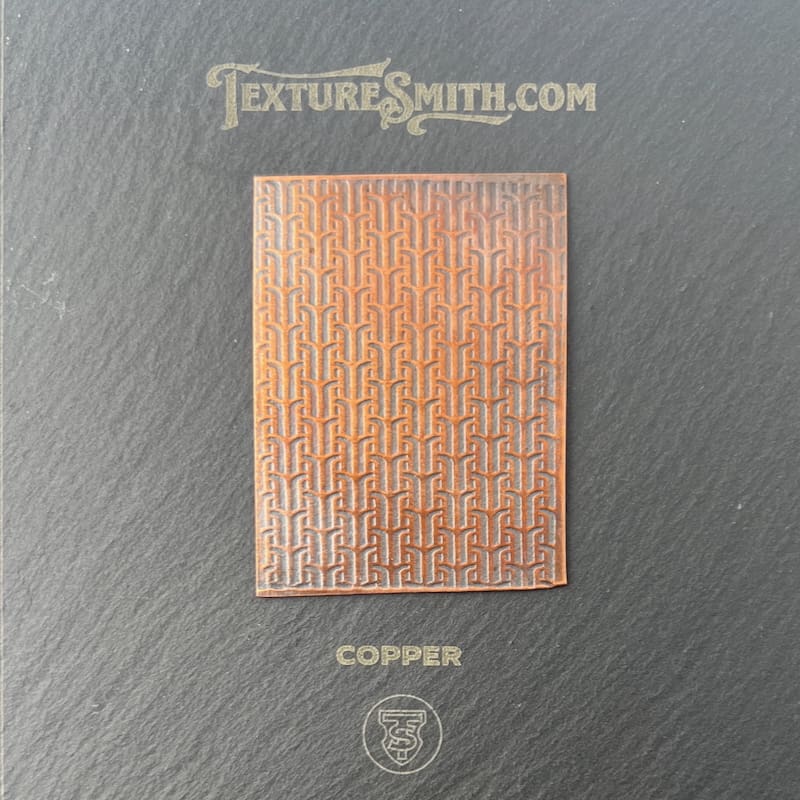 A brown textured surface with a repeating geometric pattern.