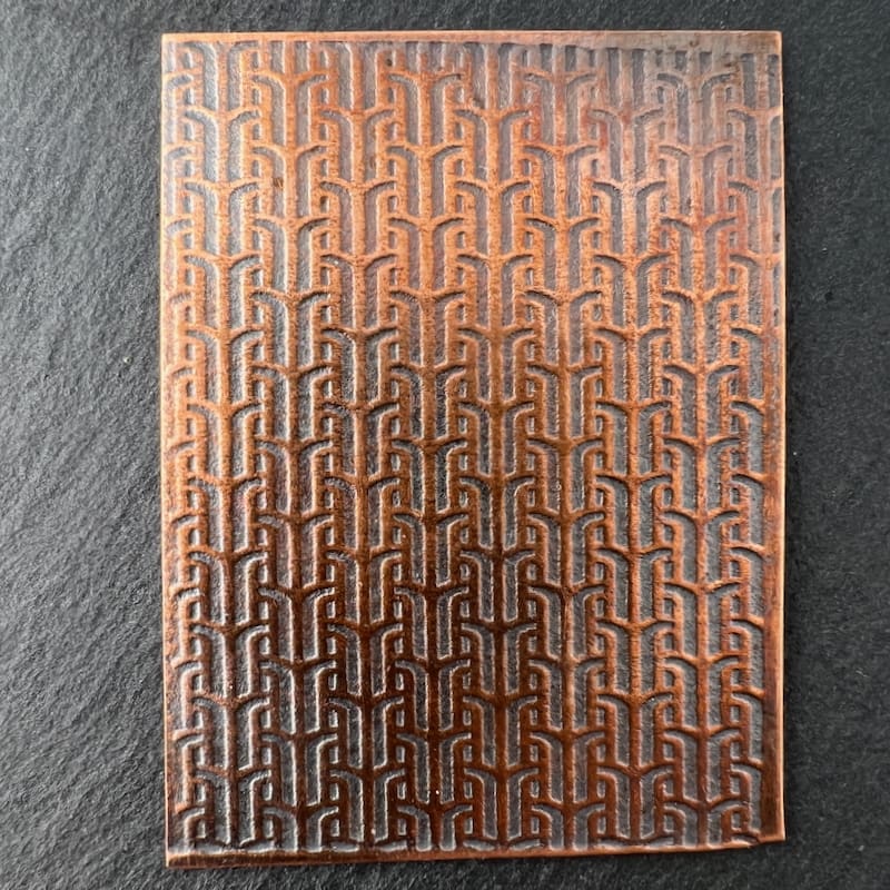 A brown textured surface with a repeating geometric pattern.