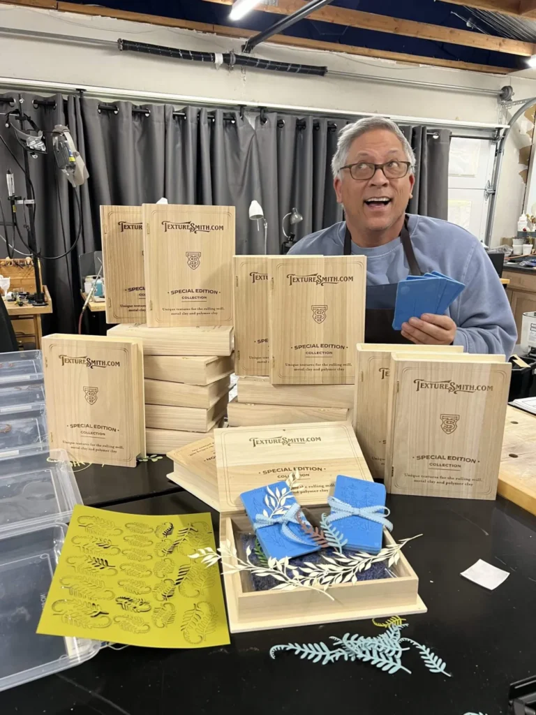 Man showcasing wooden boxes and blue packets on a table.