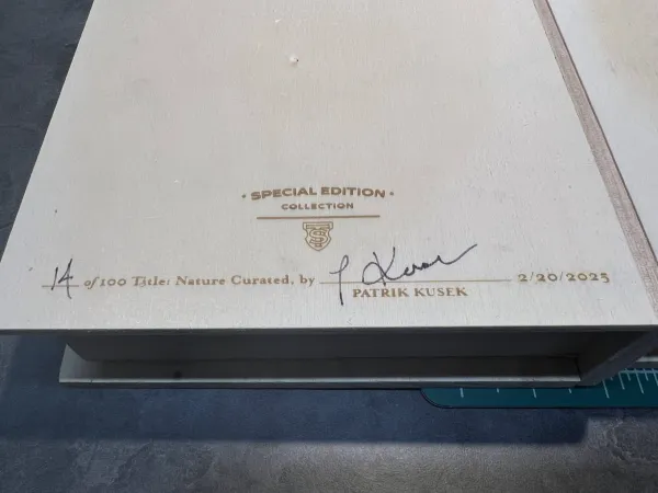 Close-up of a signed limited edition print with embossed stamp.