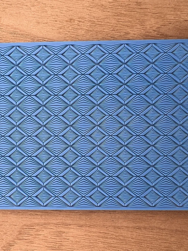Blue textured mat with a diamond pattern.