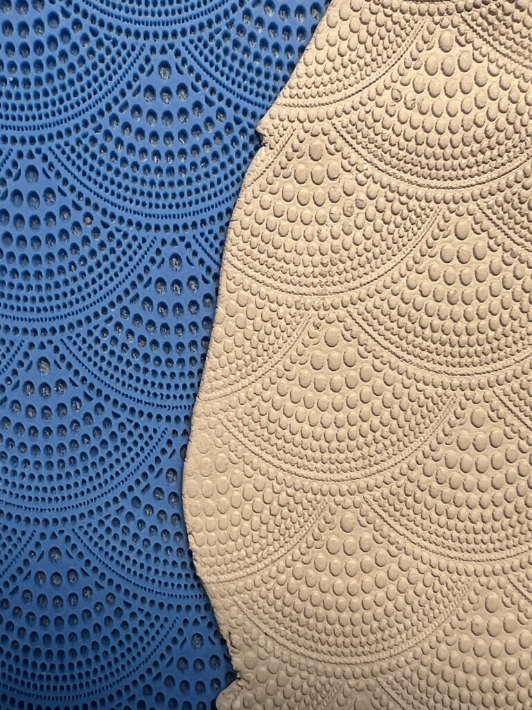 Blue and beige mats with intricate scalloped patterns.