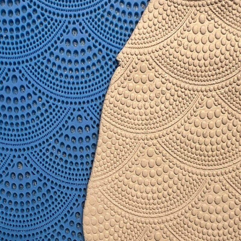 Close-up of intricately patterned blue and beige fabric textures.