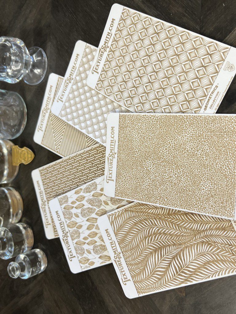 Assorted patterned papers and glassware on a table.