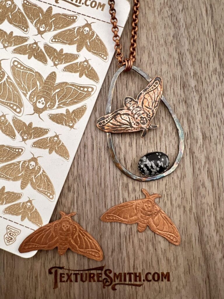 Handcrafted butterfly-themed earrings and stickers on a wooden surface.