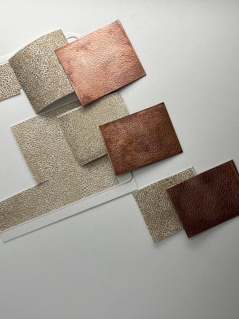 Modern wall art with mixed metal textures in copper and silver tones.